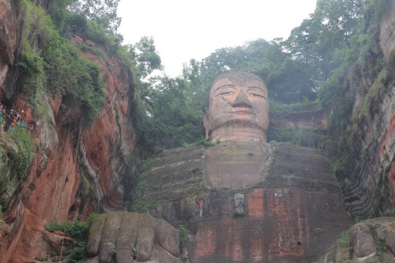 Molly from Mollywozhere showing a wide view of the Leshan Giant Buddha, China.