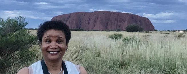 Molly from Mollywozhere travel blog standing in front of Uluru, Australia's red centre.