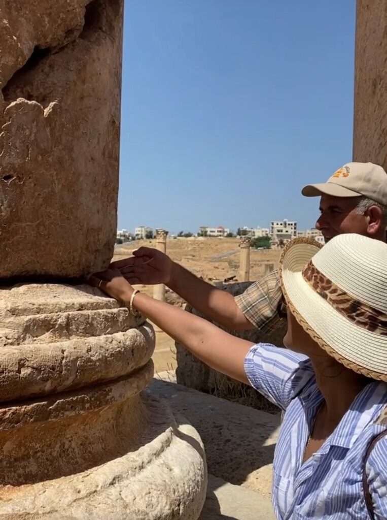 Molly from Mollywozhere travel blog being shown the swaying column trick at the Temple of Artemis using a spoon, Jerash, Jordan.