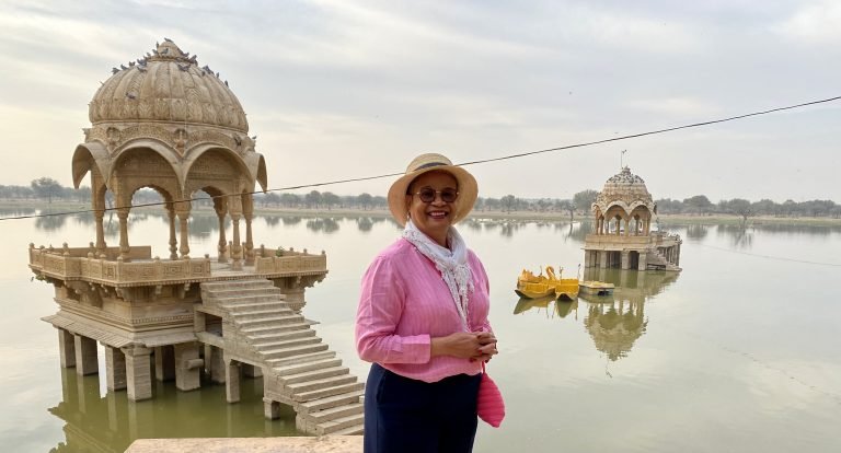 Molly from Mollywozhere travel blog standing in front of the temple in the water in Jaisalmer.