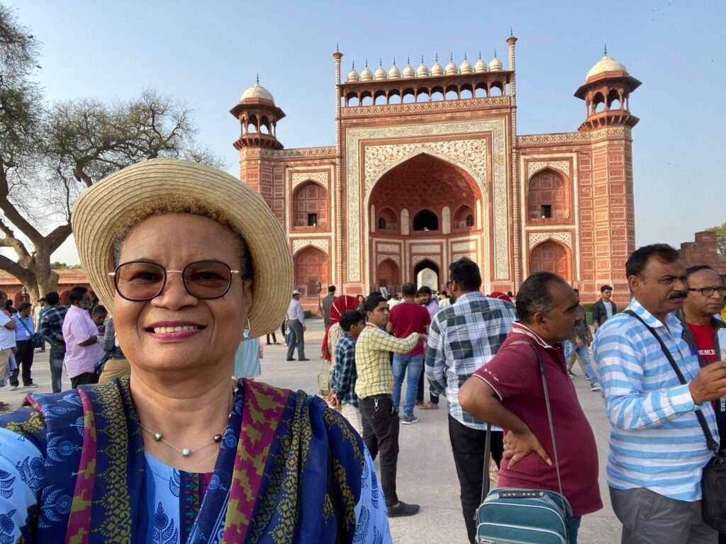 Molly from Mollywozhere travel blog standing in front of a building in the grounds of the Taj Mahal, India.