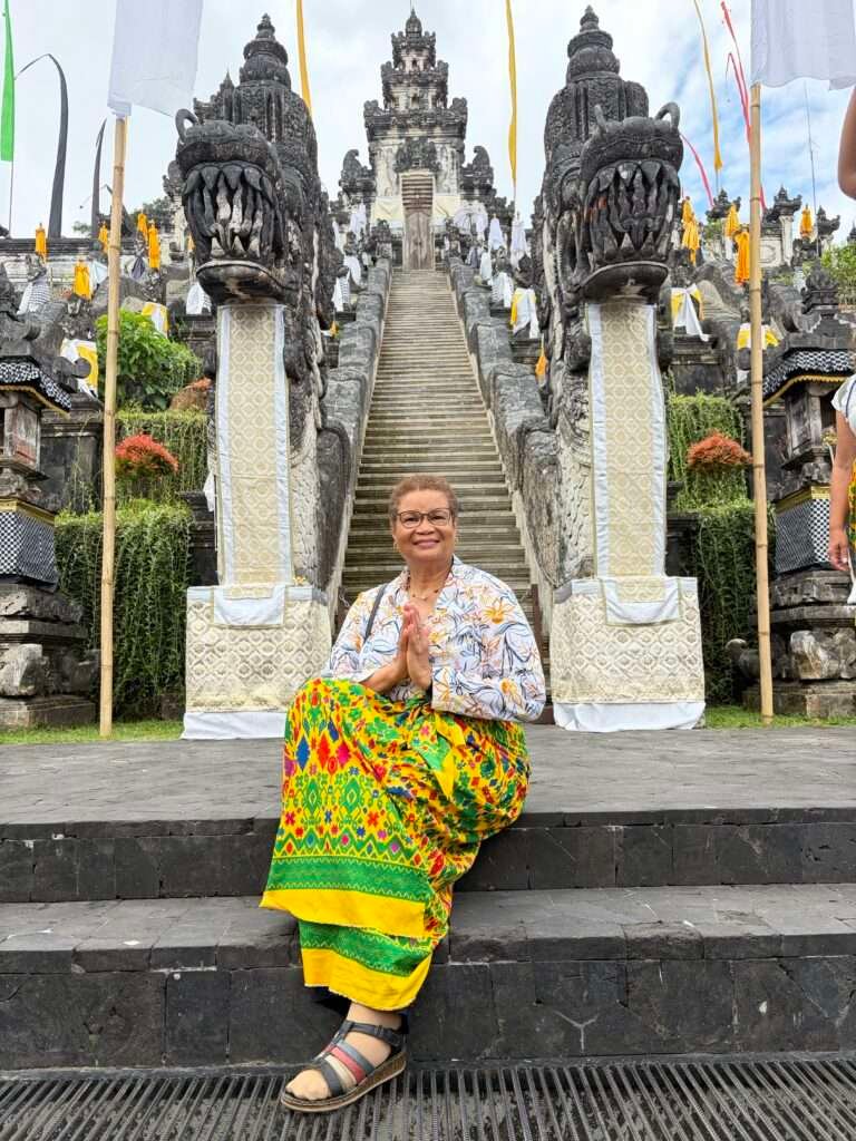 Molly from Mollywozhere travel blog sitting on the steps of the temple opposite Lempuyang Temple, Bali.