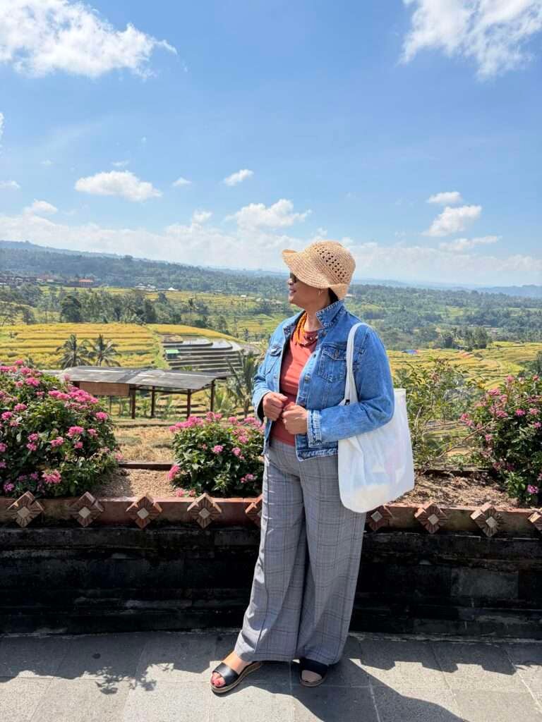 Molly of Mollywozhere standing on the terrace overlooking Jatiluwih rice terraces in Bali, Indonesia.