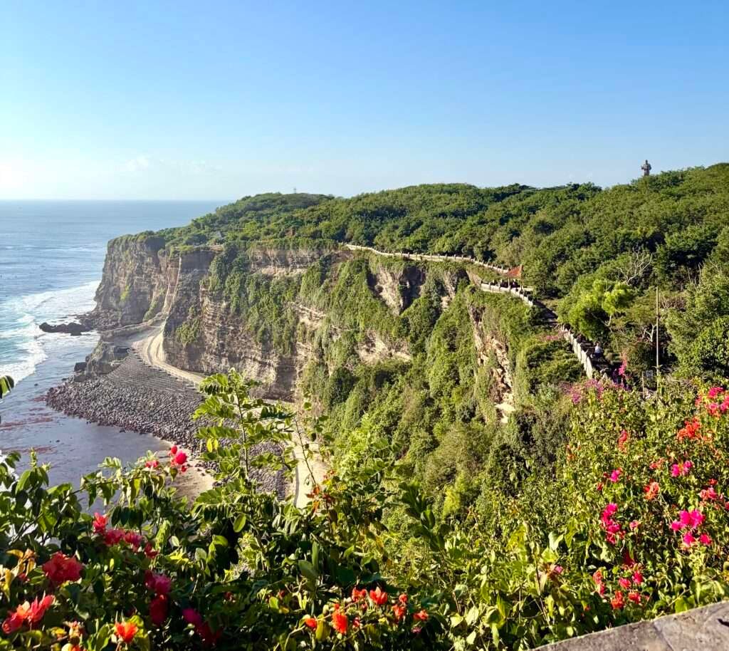 Molly from Mollywozhere looking at the dramatic and magnificent cliff edge above the Indian Ocean in Uluwatu Temple, Bali, Indonesia.