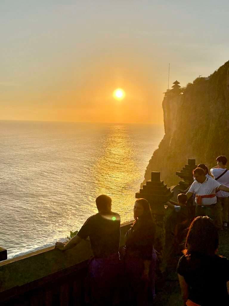 Molly from Mollywozhere travel blog looking at the dramatic sunset cliff views at Uluwatu Temple in Bali.