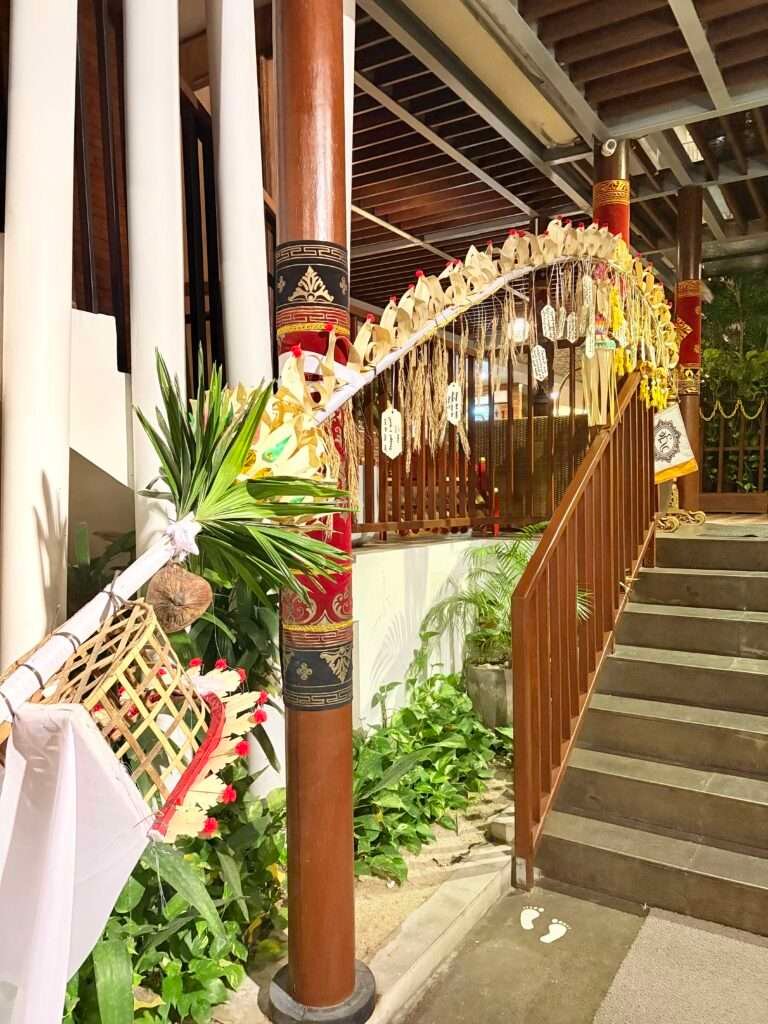 Penjor decoration on staircase with wishes tied to it, celebrating the ceremonies of Galungan