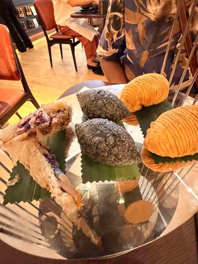 Molly from Mollywozhere travel blog showing a selection of crisp, flaky, crispy pastry of her afternoon tea with a twist at the Dim Sum Library, London.
