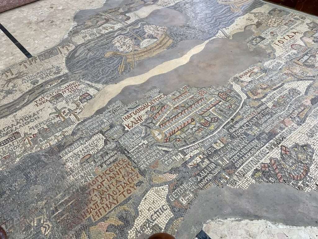 Molly from Mollywozhere travel blog showing a close up of the mosaic inside the Greek Orthodox Basilica of Saint George, Jordan.