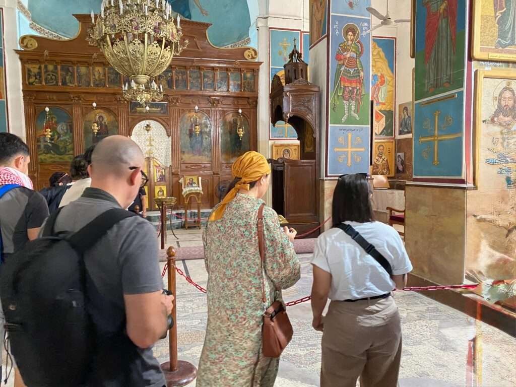 Molly from Mollywozhere standing inside the Basilica of Saint George, Madaba, Jordan.